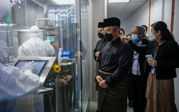Menteri Sains, Teknologi dan Inovasi Datuk Seri Dr Adham Baba bersama Timbalannya, Datuk Ahmad Amzad Mohamed@Hashim melihat proses pembotolan vaksin CanSino di Solution Biologics Sdn Bhd di Taman Teknologi Bukit Jalil hari ini. Foto Bernama