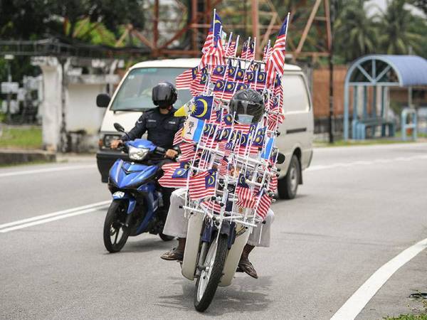 Pembantu Perawatan Kesihatan Hospital Sungai Bakap Sahul Hamid Abdullah, 53, menunggang motosikalnya yang dihiasi kira-kira 300 hingga 450 bendera mini Jalur Gemilang di setiap penjuru bagi menyambut Hari Kemerdekaan kali ke-64 pada 31 Ogos ini.