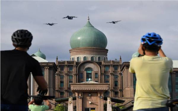 Orang ramai menyaksikan pesawat A400M dan C130H milik Tentera Udara Diraja Malaysia (TUDM) yang persembahan sempena Sambutan Hari Kebangsaan 2021 di bangunan Perdana Putra, pada Selasa. - Foto Bernama 