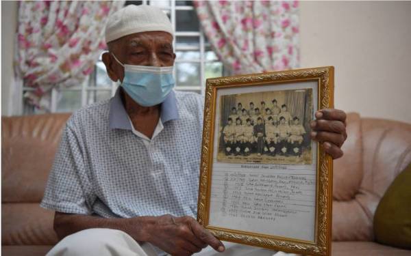 Abdullah menunjukkan gambar kenangan bersama rakan-rakannya ketika berkhidmat pada tahun 1949 ketika ditemui di Taman Sri Penunjuk, Kijal.  - Foto Bernama 
