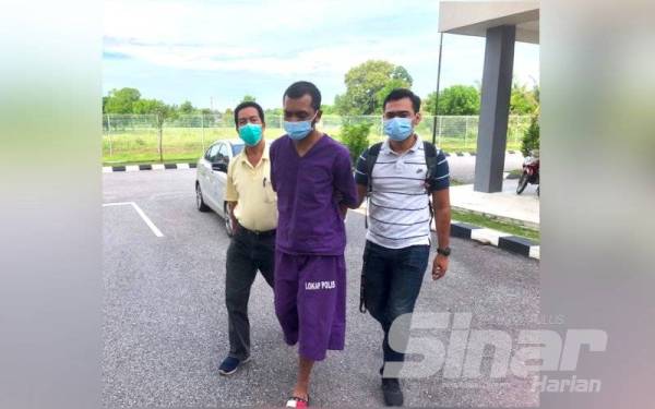 Tertuduh (tengah) dibawa keluar dari kenderaan polis menuju ke Mahkamah Sesyen untuk berdepan tuduhan cuba membunuh bapanya.