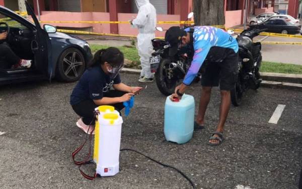 San San (kiri) bersama-sama pasukannya sedang melakukan persiapan untuk mensanitasi Pasar Awam Taman Johor Jaya, Johor Bahru yang diarah tutup seminggu.