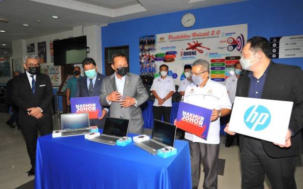 Hasni (tiga dari kiri) melihat komputer riba pada Majlis Penyerahan Komputer Riba di Jabatan Pendidikan Negeri Johor di sini pada Khamis.
