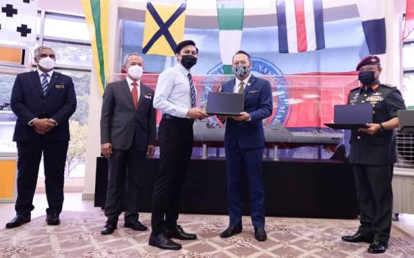 Ahmad Masrizal menyampaikan bantuan komputer riba kepada salah seorang penerima ketika melakukan lawatan kerja rasmi di Universiti Pertahanan Nasional Malaysia (UPNM) pada Khamis. FOTO: ROSLI TALIB