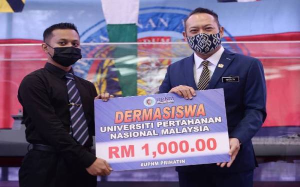 Ahmad Masrizal menyampaikan replika cek Dermasiswa kepada salah seorang penerima ketika melakukan lawatan kerja rasmi di Universiti Pertahanan Nasional Malaysia (UPNM) pada Khamis. FOTO: ROSLI TALIB