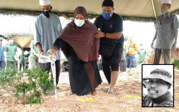 Ibu Allahyarham Mohamad Azrin, Romlah Osman, 59, dan suami, Mohamad Isa Osman, 58, (kiri) di Tanah Perkuburan Islam Kampung Pinang Dalam Sungai Petani.