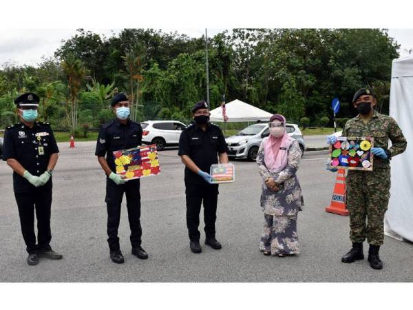 Pengarah Jabatan Perpaduan Negara dan Integrasi Nasional Melaka, Habibah Jaafar (dua, kanan) bersama sebahagian petugas barisan hadapan pada program penyerahan Kad Ucapan Penghargaan kepada Petugas Barisan Hadapan di Sekatan Jalan Raya di Ayer Keroh di sini, hari ini.