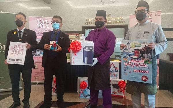 Rahmad (dua dari kanan) memegang salah satu hadiah Cabutan Bertuah Bulanan Pertama Kempen Van & Win di Seri Negeri di Ayer Keroh pada Jumaat.