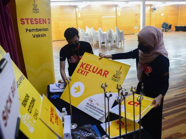 Para sukarelawan membersihkan di sekitar kawasan pemberian vaksin pada hari terakhir Pusat Pemberian Vaksin (PPV) Program Vaksin Selangor (SelVAX) di Kompleks PKNS Kelana Jaya hari ini.