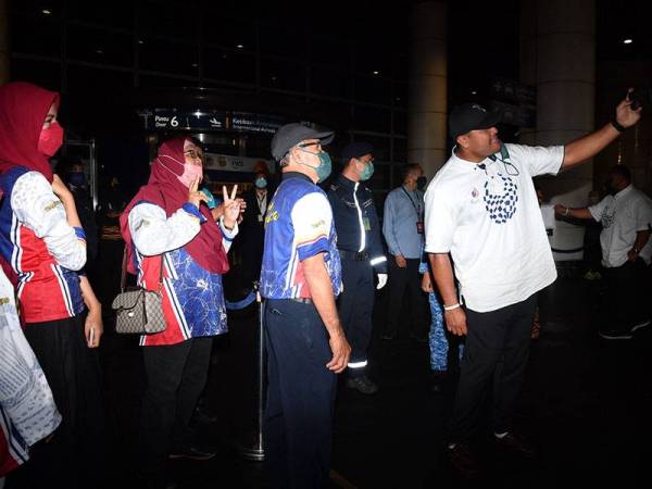 Jaguh lontar peluru negara Muhammad Ziyad Zolkefli (kanan) sempat berswafoto bersama ahli keluarganya sejurus tiba di Lapangan Terbang Antarabangsa Kuala Lumpur (KLIA) hari ini.