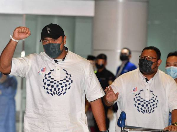 Jaguh lontar peluru negara Muhammad Ziyad Zolkefli (kiri) bersama jurulatihnya tiba di Lapangan Terbang Antarabangsa Kuala Lumpur (KLIA) hari ini.