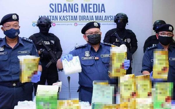 Abdul Latif (tengah) bersama dadah yang cuba diseludup masuk ke negara ini.