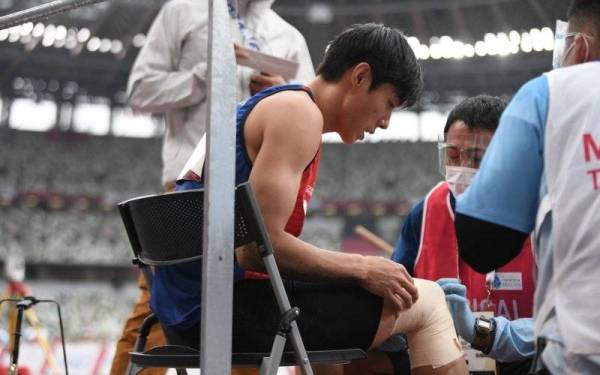 Kar Gee mendapatkan rawatan selepas mengalami kecederaan ketika melakukan lompatan dalam kategori T11/12 (masalah penglihatan) pada temasya sukan Paralimpik Tokyo 2020 di Stadium Olimpik, Tokyo pada Sabtu. - Foto Bernama