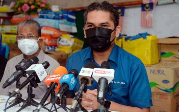 Mohd Radzi (kanan) mengadakan sidang akhbar selepas meninjau sekitar Sekolah Kebangsaan Haji Nyak Gam yang rosak akibat dinaiki banjir lumpur ketika melawat sekolah itu pada Sabtu. - Foto Bernama