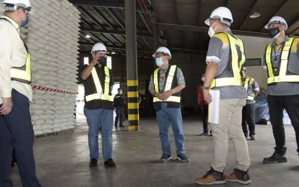 Ronald (dua dari kiri) dan Jeffrey (tiga dari kanan) ketika melakukan lawatan pemeriksaan gudang simpanan beras stok stokpail negara di Telipok, Kota Kinabalu pada Sabtu.
