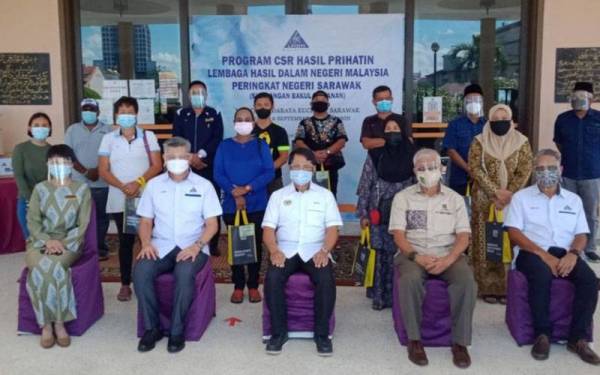 Mohd Saiful Sungkih (duduk, tengah) bersama Abang Abdul Wahab (duduk, dua dari kanan), Abang Ehsan (duduk, dua dari kiri) serta wakil-wakil penerima sumbangan dalam Program CSR Hasil Prihatindi Masjid Bandaraya Kuching.