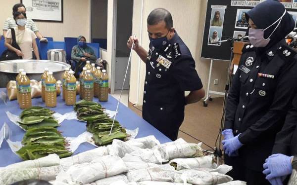 Ayob Khan menunjukkan daun dan air ketum yang dirampas dalam tujuh serbuan di seluruh Johor, selepas sidang akhbar di IPK Johor, Johor Bahru, pada Selasa.