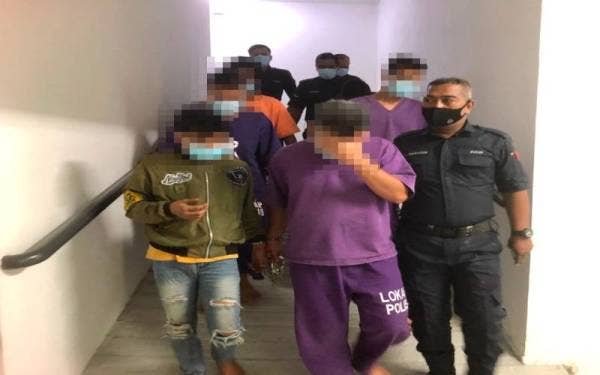 Suspek yang berusia 38 tahun (tengah) dikawal polis keluar dari lokap menuju ke Mahkamah Majistret Kota Bharu pada Rabu.