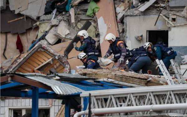 Anggota penyelamat melakukan pemeriksaan di kawasan terlibat. - Foto EPA 