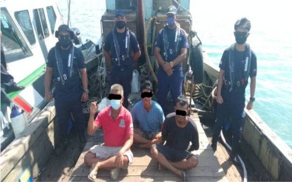 Sebahagian kru bot pukat tunda yang ditahan menerusi operasi di kawasan Taman Laut Johor pada Selasa.- Foto Jabatan Perikanan Johor