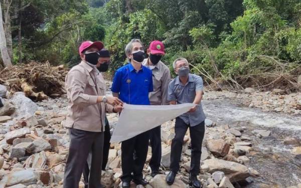 Dari kiri Abdullah dan Azhari ketika melakukan tinjauan dan melihat aliran sungai di Pusat Rekreasi Titi Hayun, Yan pada Khamis.
