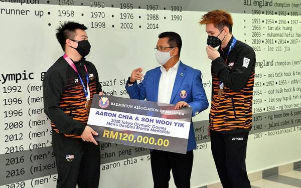 Presiden Persatuan Badminton Malaysia (BAM), Tan Sri Mohamad Norza Zakaria (tengah) beramah mesra dengan Aaron Chia dan Wooi Yik pada Majlis Penyampaian Insentif BAM di ABM pada Khamis.