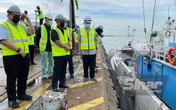 Ronald (tengah) melihat proses pendaratan ikan tuna di Dermaga Ayer Dalam, Butterworth pada Khamis.