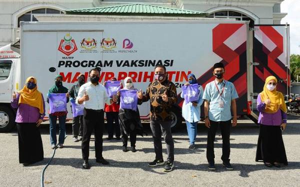 Amilludin (tengah) dan Mahadi (depan, dua dari kiri) bergambar selepas penyerahan sumbangan daripada Pusat Pakaian Hari-Hari di PPV MAIWP Dewan Komuniti Sri Petaling, Bukit Jalil, Kuala Lumpur pada Jumaat.