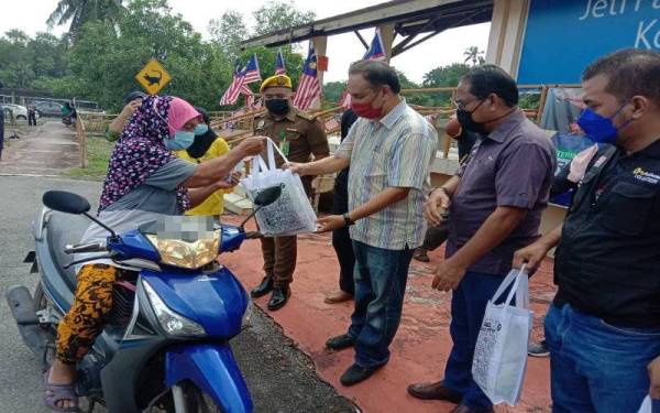 Awaludin (tiga kanan) ketika menyampaikan sumbangan kepada penerima.