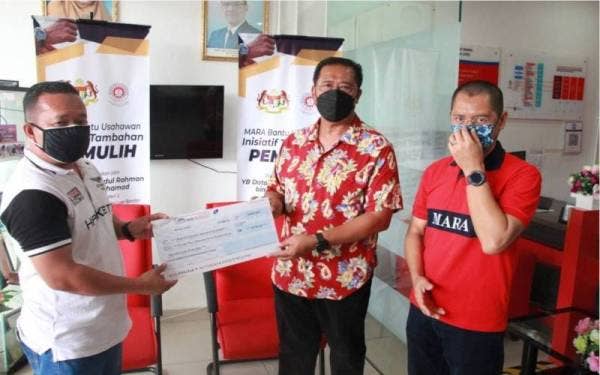 Abdul Rahman (dua dari kanan) menyampaikan sumbangan kepada usahawan di Pahang.