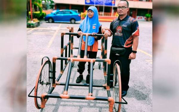 Wan Muadzam Wan Abidin membantu Nur Yusrina Alisya Yusri ketika menggunakan Caballus Rafvi bagi membantu murid istimewanya berlari dengan sempurna. - Foto Bernama