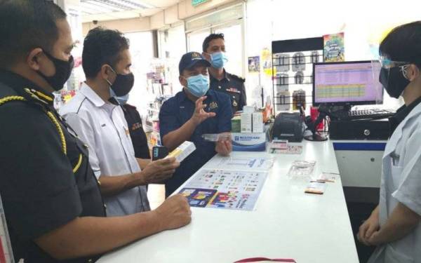  Muhamad Zikril melakukan pemeriksaan harga kit ujian Covid-19 di tiga farmasi di daerah Sabak Bernam.