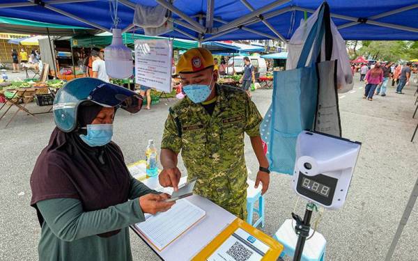 Petugas Rela memeriksa E-Sijil Mysejahtera seorang pengunjung yang datang ke pasar ketika tinjauan Foto Bernama di tapak pasar malam Taman Jaya hari ini. 
