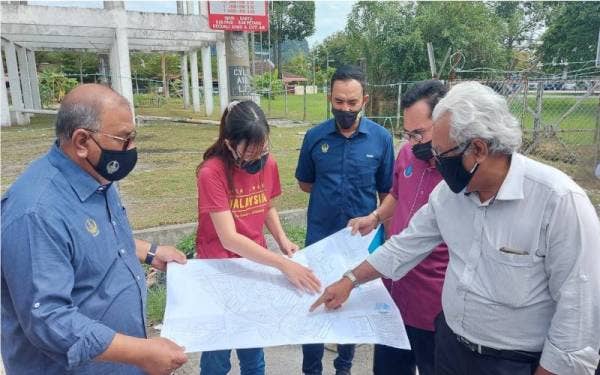 Mohd Zolkafly (kiri) dan Jenny (dua dari kiri) melihat peta yang disediakan LAP bagi bekalan air di Taman Ipoh Timur.