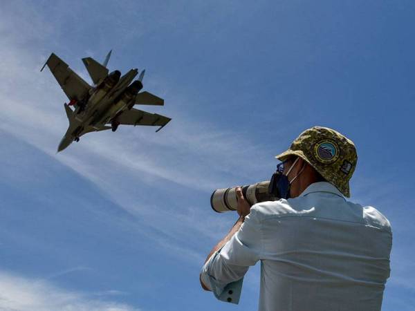 Seorang lelaki tidak melepaskan peluang merakam gambar aksi pesawat pejuang Sukhoi Su-30MKM milik Tentera Udara Diraja Malaysia (TUDM) ketika melakukan terbang lintas di ruang udara Labuan sempena acara kemuncak Eksesais Ababil 2021 hari ini.