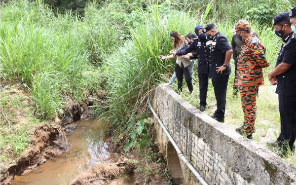 Ayob Khan (tengah) meninjau keadaan tali air dan Sungai Tawakal di Kampung Baru Sri Aman yang mengalami pencemaran bahan kimia.