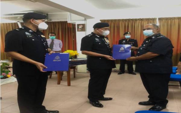 Shafien (tengah) diiringi Ketua Polis Daerah Bachok, Deputi Superintendan Mohamad Ismail Jamaluddin (kiri) menyampaikan sijil penghargaan kepada Ketua Balai Polis Jelawat, Sarjan Mejar Khalid Yusof.
