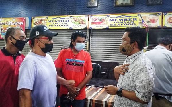 Jalaluddin (kanan) bertemu peniaga berhubung isu bekalan elektrik sebahagian premis di Medan Selera D'Rejang dikenakan tindakan pemotongan elektrik.
