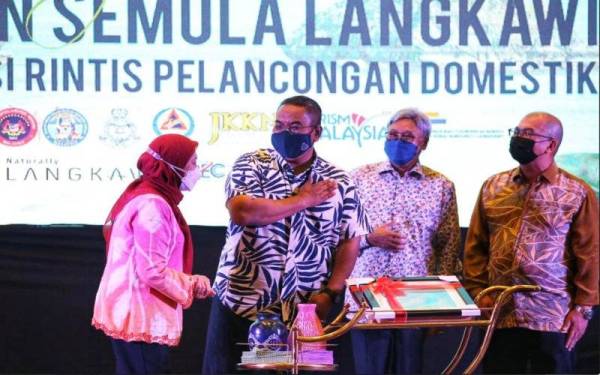 Muhammad Sanusi (dua dari kiri) bersama Nancy (kiri) pada majlis pelancaran pembukaan semula Langkawi sebagai destinasi rintis pelancongan domestik di Langkawi pada malam Rabu.