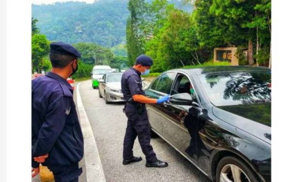 Anggota polis dari IPD Bentong yang melakukan pemeriksaan terhadap orang ramai di KM 17 laluan ke Genting Highlands pada Rabu.