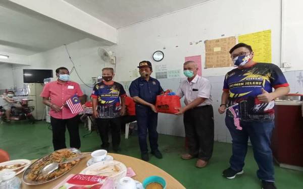 Jalaluddin (tengah) ketika menyampaikan bakul makanan kepada penerima terlibat.