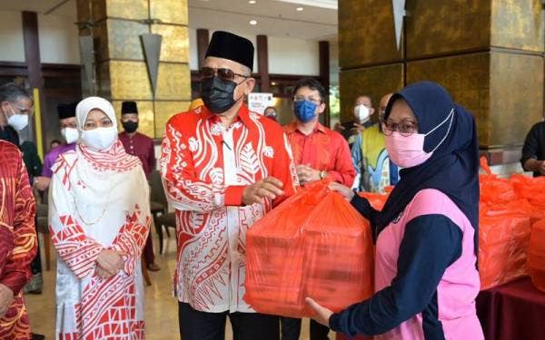 Shahidan (dua dari kanan) pada sesi penyerahan pek makanan kepada petugas barisan hadapan.
