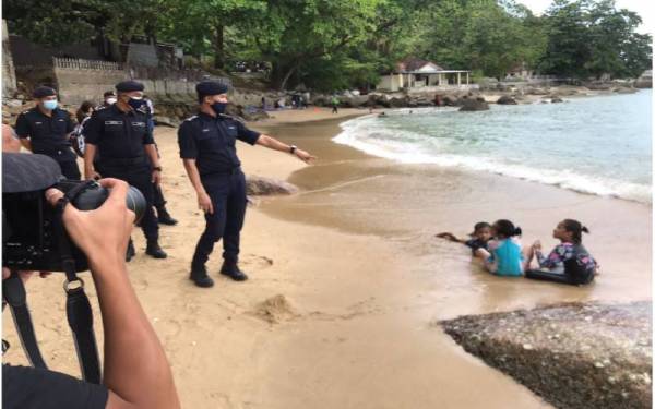 Mohd Shuhaily (tengah) meninjau kawasan pantai di Tanjung Bungah.