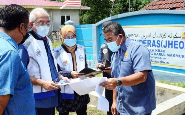 Mahdzir (dua dari kiri) bersama Ismail (kanan), Abdul Rahman (kiri) dan Sapiah (tiga dari kiri) melihat data dan maklumat mengenai PKRC di Kampung Penderas, Temerloh pada Khamis.
