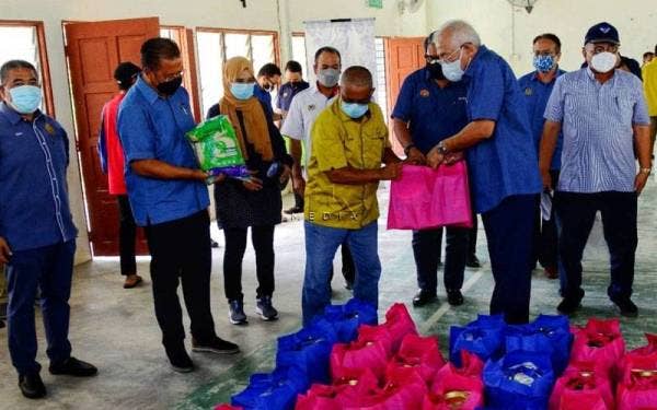 Mahdzir(kanan) menyampaikan beras kepada wakil penduduk kampung tersebut.