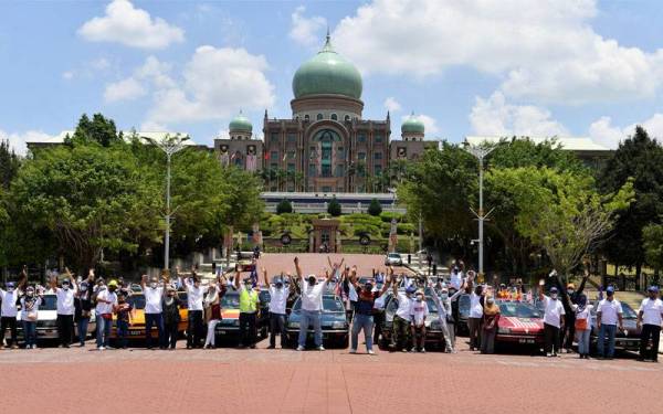Para pemilik kereta Proton Saga dari Kelab Saga 69 Bukit Kapar Klang bergambar di hadapan Bangunan Perdana Putra. Foto Bernama