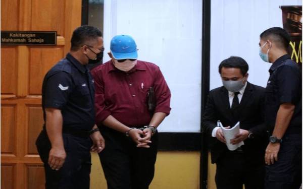 Tertuduh (dua dari kiri) didakwa di Mahkamah Sesyen Teluk Intan pada Jumaat atas 32 pertuduhan melakukan seks luar tabii dan amang seksual fizikal terhadap tujuh pelajar lelaki tahun lalu.