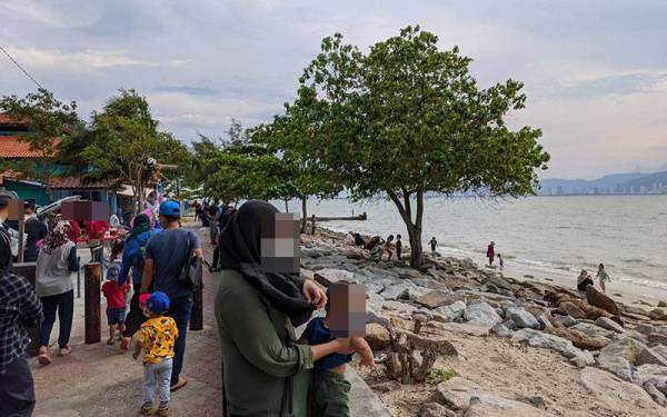 Keadaan Taman Rekreasi Pantai Robina di Teluk Air Tawar, Kepala Batas yang dipenuhi pengunjung pada Khamis.