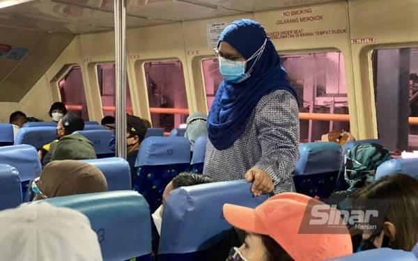 Exco Pelancongan Perlis, Asmaiza Ahmad meninjau penumpang yang menaiki feri untuk berlepas ke Pulau Langkawi di Terminal Feri Kuala Perlis pada Jumaat.