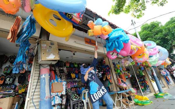 Suasana Pantai Chenang kembali sibuk dengan pelbagai urus niaga selepas kedai-kedai jualan kembali beroperasi semula dengan pembukaan gelembung pelancongan Langkawi. - Foto Bernama